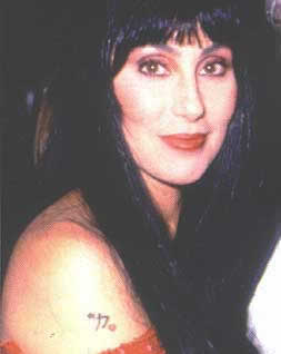 Cher in a red dress showing her tattoos