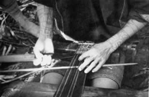 Basadung Li woman weaving a tubeskirt with backstrap loom