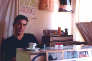 Naki’s tattoo mannequins, top, in his studio. The old tattoo price list above his head in Albanian.