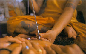Monk using tattooing instrument