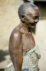Elaborate palm frond tattoos adorn the arms of this elderly Makonde woman.